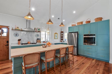 Kitchen with wood counters, wall chimney exhaust h
