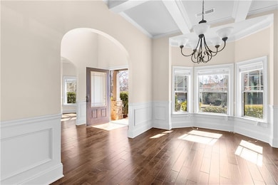 Entryway with arched walkways, a wainscoted wall, 