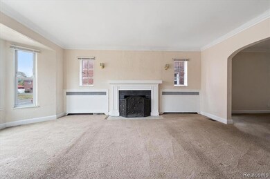 Unfurnished living room with arched walkways, radiator, carpet flooring, a fireplace with flush hearth, and crown molding