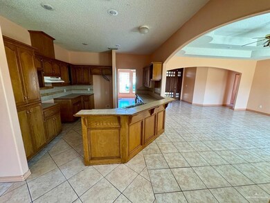 Kitchen with a textured ceiling, tasteful backsplash, light tile floors