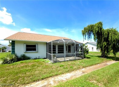 Rear view of property with a lawn, stucco siding,
