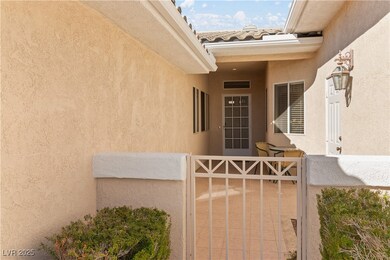 View of exterior entry with a tile roof and stucco