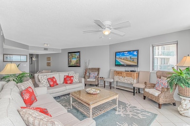 Living area featuring tile patterned floors, a textured ceiling, and a ceiling fan