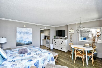 Bedroom with dark wood-type flooring, white fridge