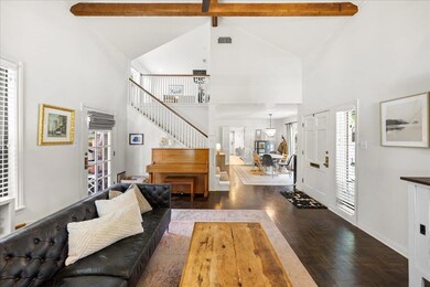 Living area with high vaulted ceiling, beamed cei