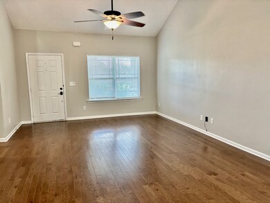 Walk into a large Den with vaulted ceilings, ceiling fan, open floor plan to kitchen and Dining Room area.
