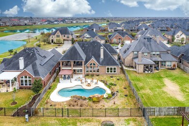 Vacation from home in this lakefront backyard featuring a salt water lagoon-style pool, gas firepit, gazebo and outdoor kitchen!