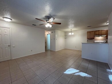 Unfurnished living room with a chandelier, a ceiling fan, a textured ceiling, and light tile patterned floors