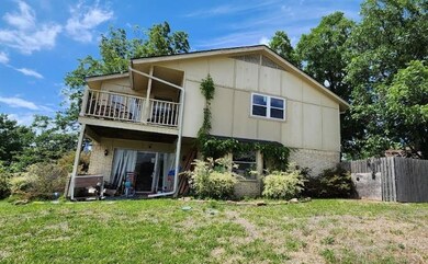 Rear view of property featuring a balcony and a ya