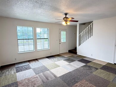 Foyer entrance with a ceiling fan, carpet floorin