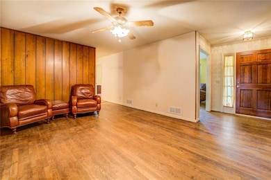 Living area featuring visible vents, ceiling fan, 