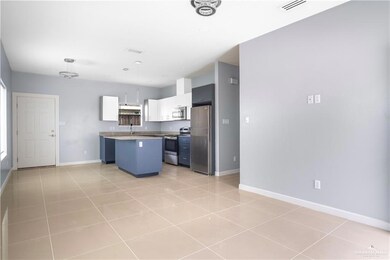 Kitchen with stainless steel appliances, a center island, and light tile patterned flooring