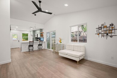 Living area with ceiling fan, light wood-style fl