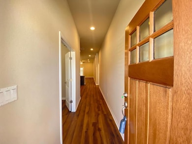 Hall featuring wood finished floors, recessed lig