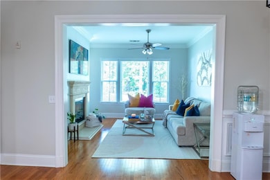 Living room featuring crown molding, light hardwoo