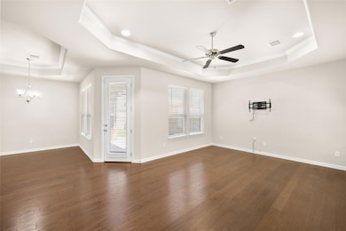 Living room with a raised ceiling, ceiling fan wit