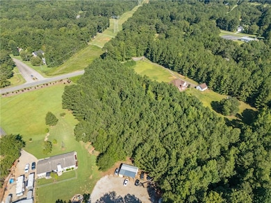 Aerial view of property and surrounding area with a forest