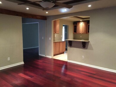 A view of the living room from the kitchen is bene