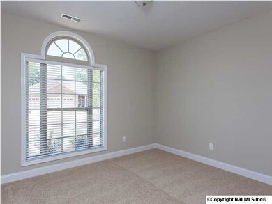 Beautiful paladian window allows lots of sunlight into this bedroom.