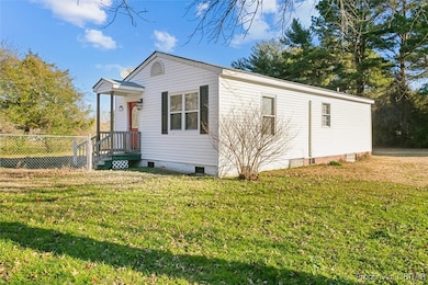 View of side of property featuring a lawn