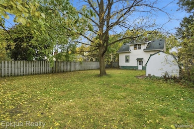 Fenced backyard featuring an outbuilding