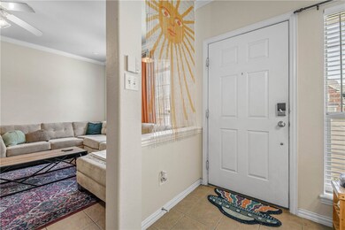 Foyer featuring crown molding, light tile patterne