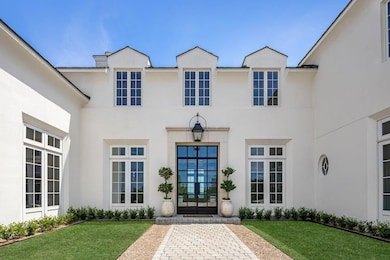 View of exterior entry featuring a yard and stucc