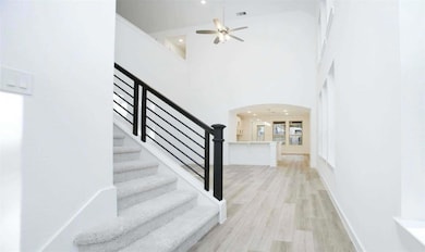 Stairway featuring arched walkways, a ceiling fan