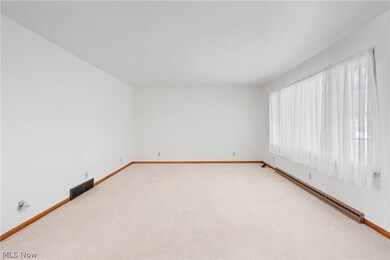 Carpeted empty room with a baseboard radiator