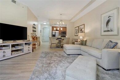 Living room with a notable chandelier and light wood-type flooring