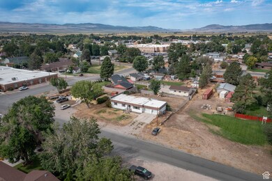 Aerial view of property and surrounding area featuring a mountain backdrop and nearby suburban area