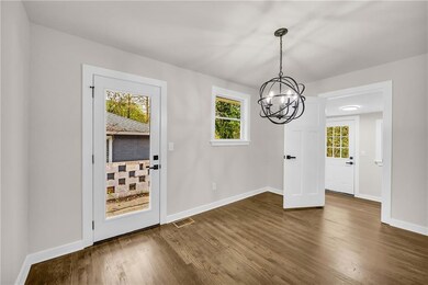 Unfurnished dining area with dark wood-style floors and a chandelier