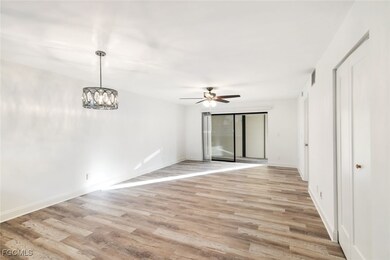 Spare room with light wood finished floors, a chandelier, and ceiling fan