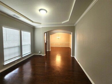 Hallway with crown molding, a textured ceiling, dark hardwood / wood-style floors, and an inviting chandelier