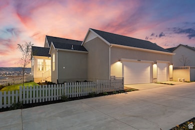View of front of house featuring a fenced front yard, driveway, a shingled roof, stucco siding, and an attached garage