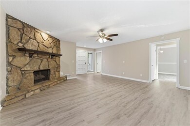 Unfurnished living room featuring a fireplace, light wood-type flooring, and a ceiling fan
