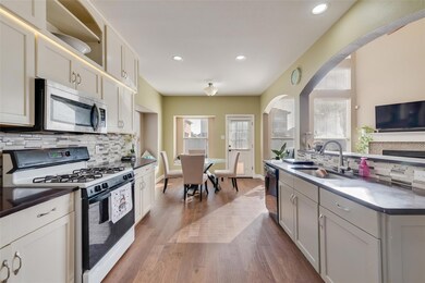 Kitchen featuring sink, white cabinets, white gas 