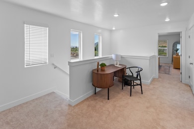 Sitting room featuring light carpet, an upstairs landing, recessed lighting, and a textured ceiling