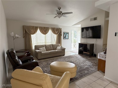 Living room featuring a ceiling fan, light tile pa