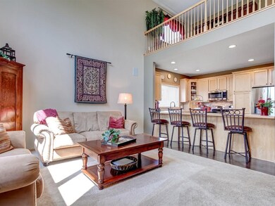 Great room has high vaulted ceilings open to the s