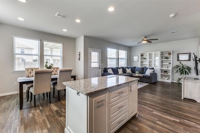 Kitchen featuring a ceiling fan, dark wood-style 