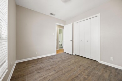 Unfurnished bedroom featuring dark wood-style flooring and a closet