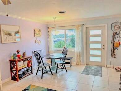 Dining room with crown molding and light tile patterned floors