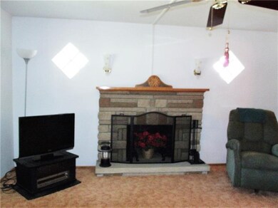 Living room with stone log burning fireplace, neut