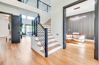 Staircase featuring wood finished floors and a towering ceiling