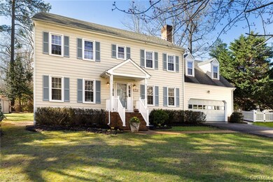 Colonial-style house with a front yard and a garage