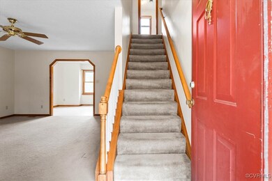 Staircase with ceiling fan and carpet floors