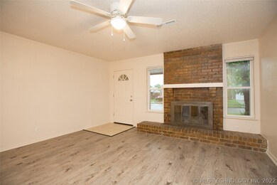 Living Room with updated flooring and brick firepl