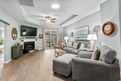 Living room with a ceiling fan, light wood finishe