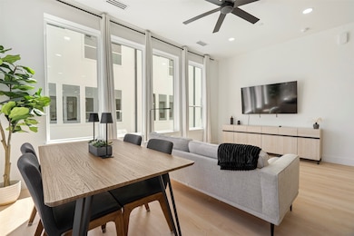 Living area with recessed lighting, visible vents, light wood finished floors, and baseboards